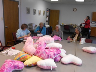 Stuffing and sewing heart pillows.